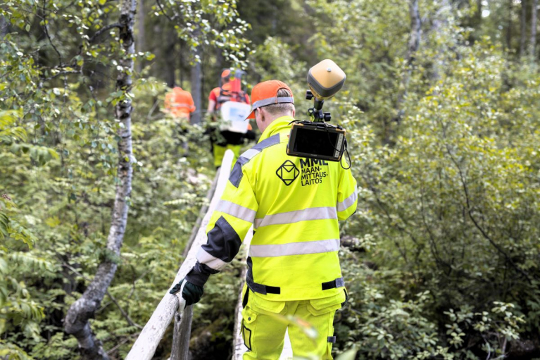 Maanmittarit maastotyössä Kalevalapuistossa Suomussalmella