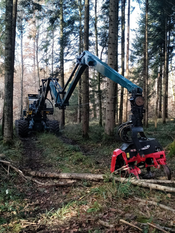 Outreach machine with extended boom in the forest.