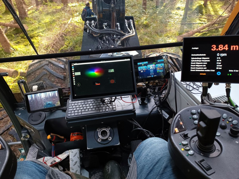 View into the cabin of the Outreach feller-forwarder with additional screens for operator assistance.