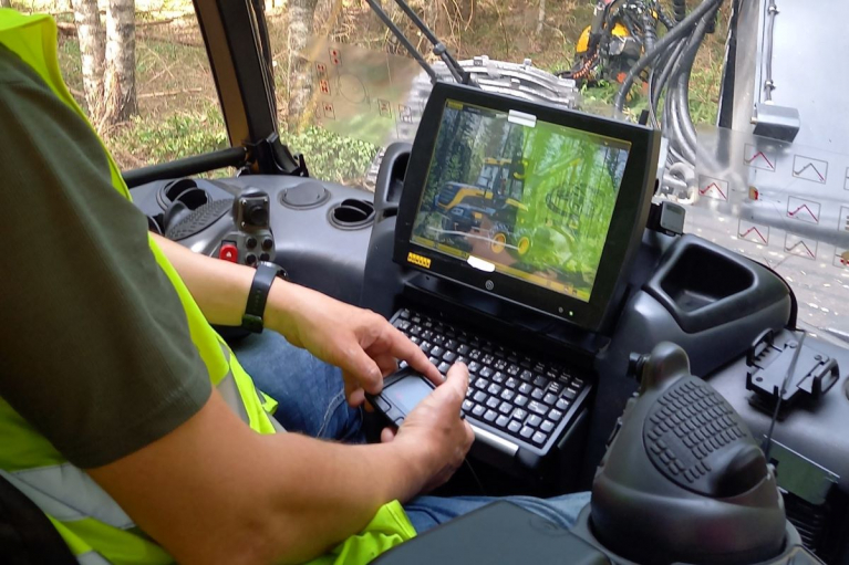 metsäkoneenkuljettaja koneen ohjaamossa