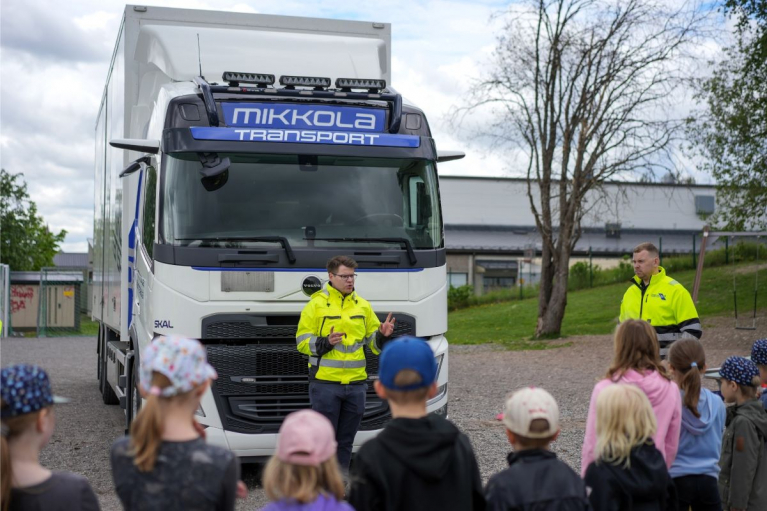 Volvo Trucksin tuotepäällikkö Antti Heinonen puhuu koululaisille kuorma-auton edessä Mäntsälän Ehnroosin koulun liikenneturvallisuustapahtumassa.