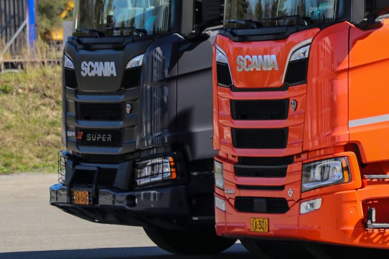 Mustan ja punaisen Scania-kuorma-auton keulat vierekkäin.