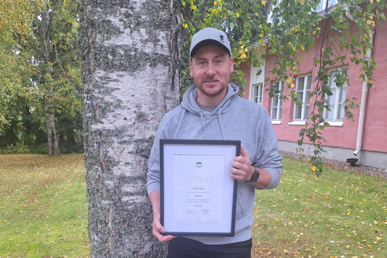 Jukka Laulainen pitää kädessään Metsämiesten Säätiön Työyhteisön hyvä tyyppi -stipendiä Kuopiossa.