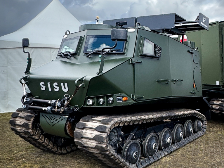 SISU tracked tactical vehicle equipped with a Rumble Tools robotic helicopter docking station.