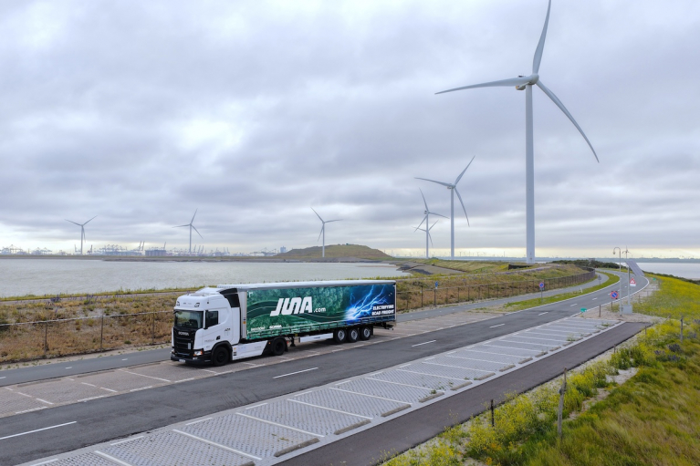 JUNA electric truck driving through a wind farm in the Netherlands.
