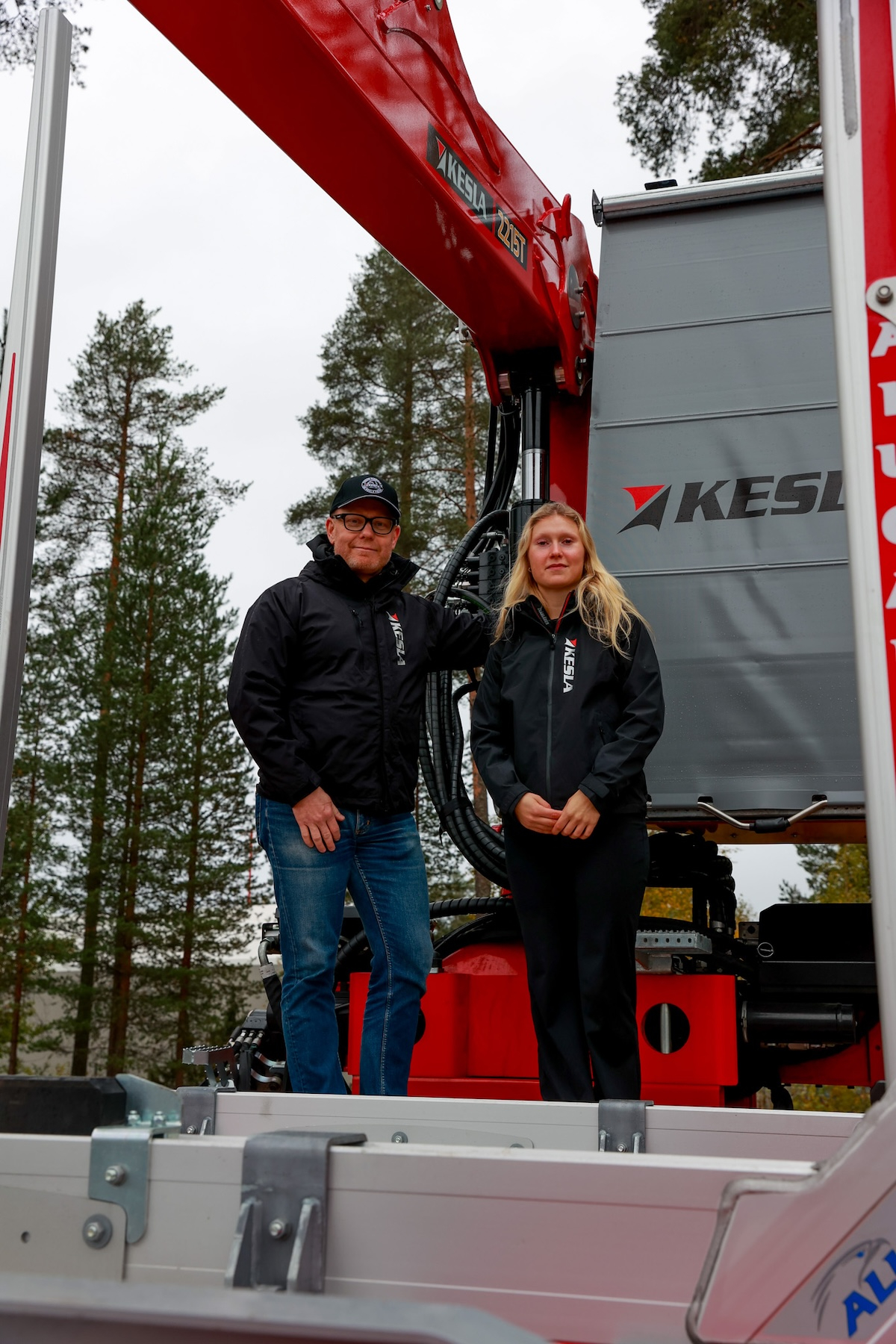 Kesla CEO Pasi Nieminen and Finnish biathlete Inka Hämäläinen standing beside a Kesla forestry crane.