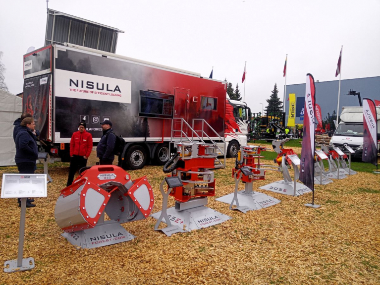 Nisulan puutavara- ja energiakouria esillä Maamessillä. Taustalla on Nisulan esittelyauto ja messuvieraita.