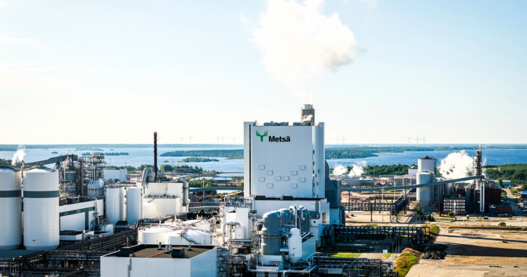 Metsä Groupin Kemin biotuotetehtaan rakennuksia, säiliöitä ja putkistoja. Taustalla näkyy meri.