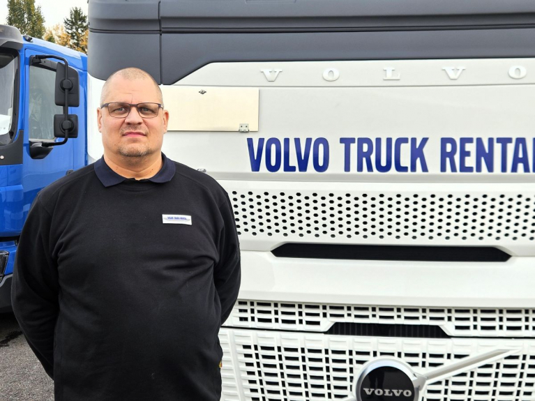 Jussi Riikonen seisoo Volvo Truck Rentalin valkoisen kuorma-auton edessä.
