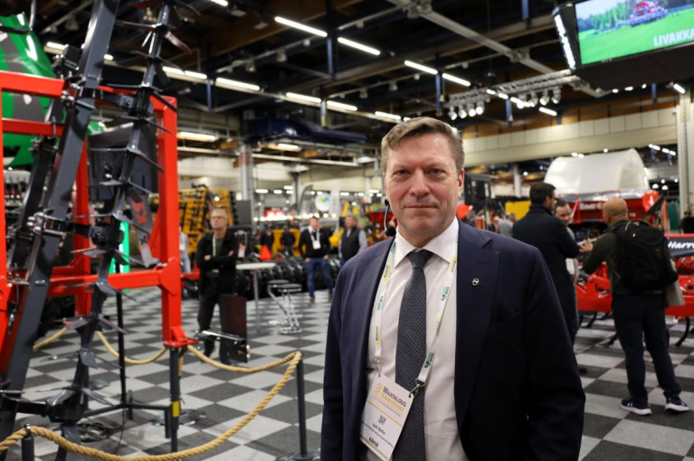 MTK:n toiminnanjohtaja Jyrki Wallin Maatalouskonemessuilla Helsingin Messukeskuksessa. Taustalla maatalouskoneita ja messuvieraita.