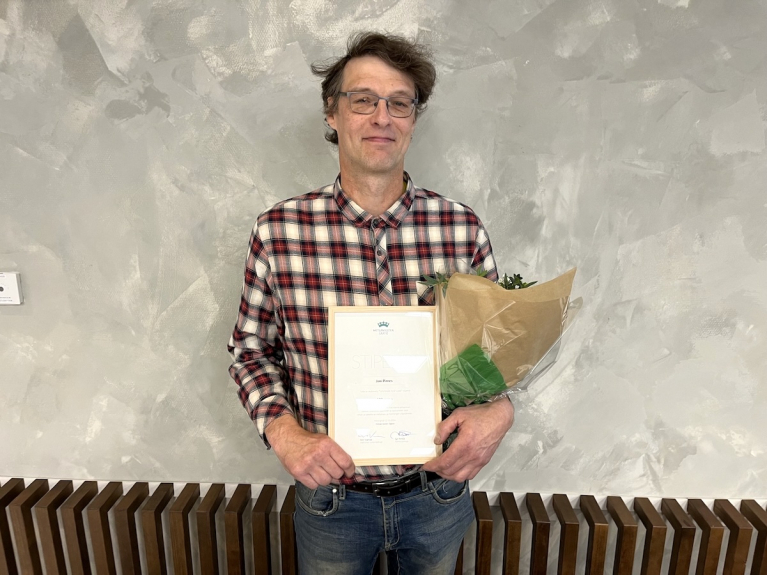 Metsuriyrittäjä Jani Pirnes Ylivieskasta pitelee Metsämiesten Säätiön stipendiä ja kukkakimppua.
