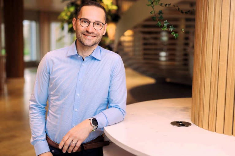 Martin Chovan, Sales Director at Södra Cell, wearing glasses and a light blue shirt in an office with wooden interior details.
