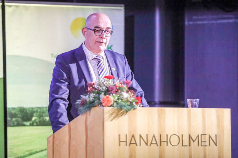 Mikko Tiirola puhuu puisessa puhujakorokkeessa Espoon Hanasaaressa.