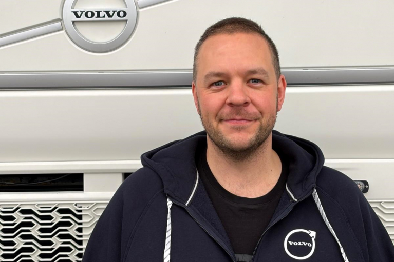 Tatu Tainio seisoo valkoisen Volvo-kuorma-auton edessä.