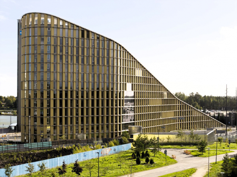 Timber-clad façade of Keilaniemen Portti in Espoo, Finland, with a roofline sloping down from its tallest end.