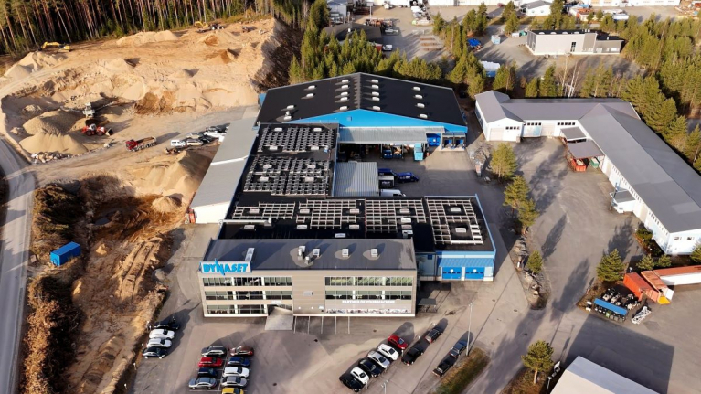 Ilmakuva Dynasetin tehdas- ja toimistorakennuksista, joiden katoilla on aurinkopaneeleja.